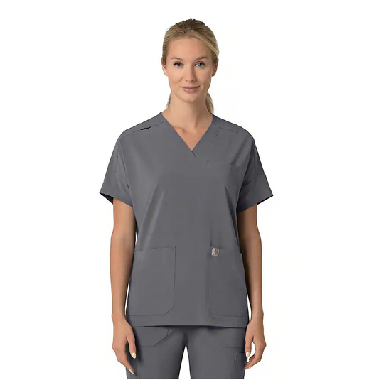 Person wearing a gray scrub top with a visible brand logo on a white background